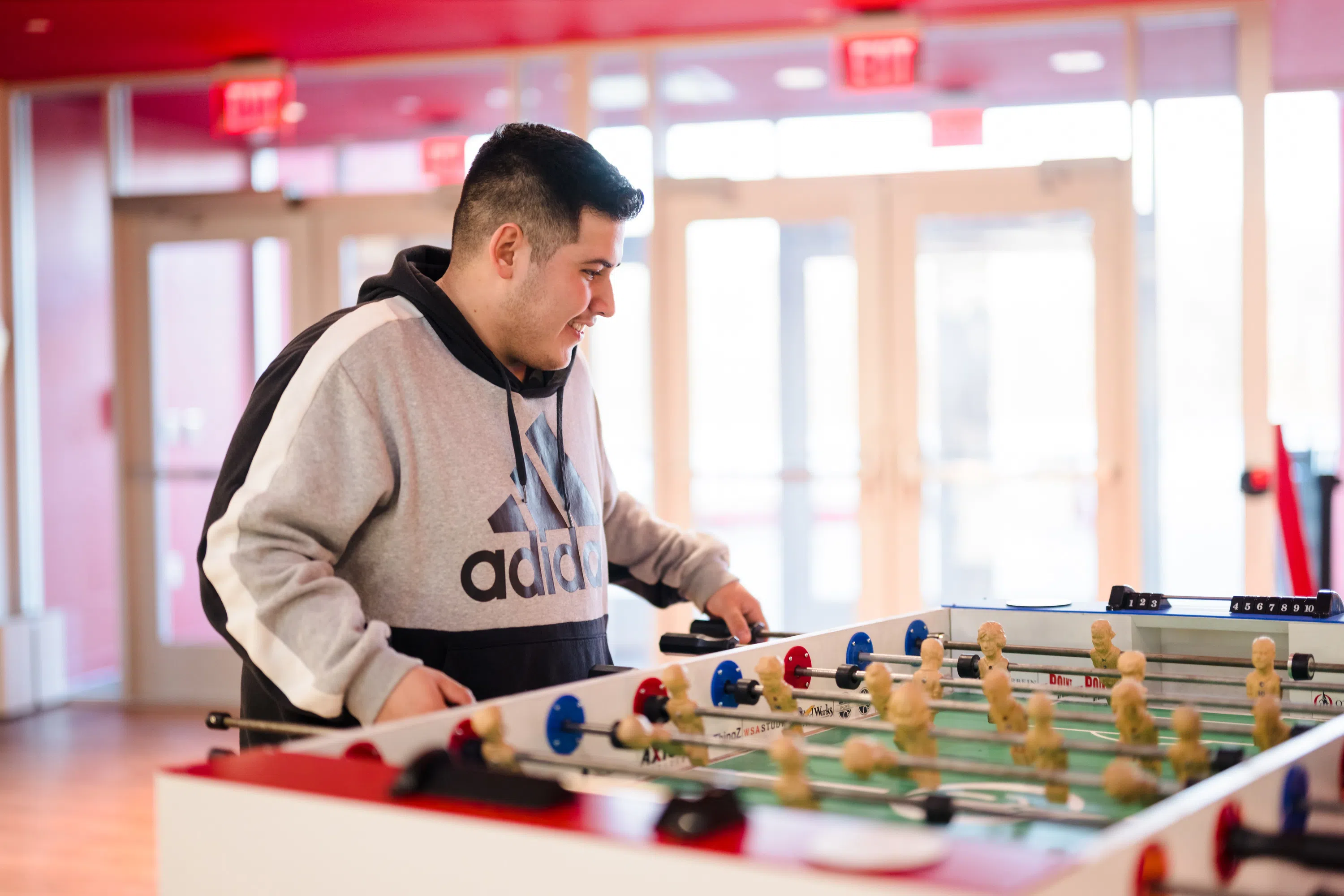 A man is playing foosball happily