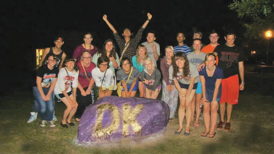 A group of Dunlap King residents pose after just repainting "The Rock" - a large boulder on campus - an Otterbien student tradition.
