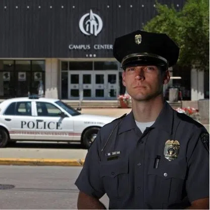 An officer with their cruiser in the back