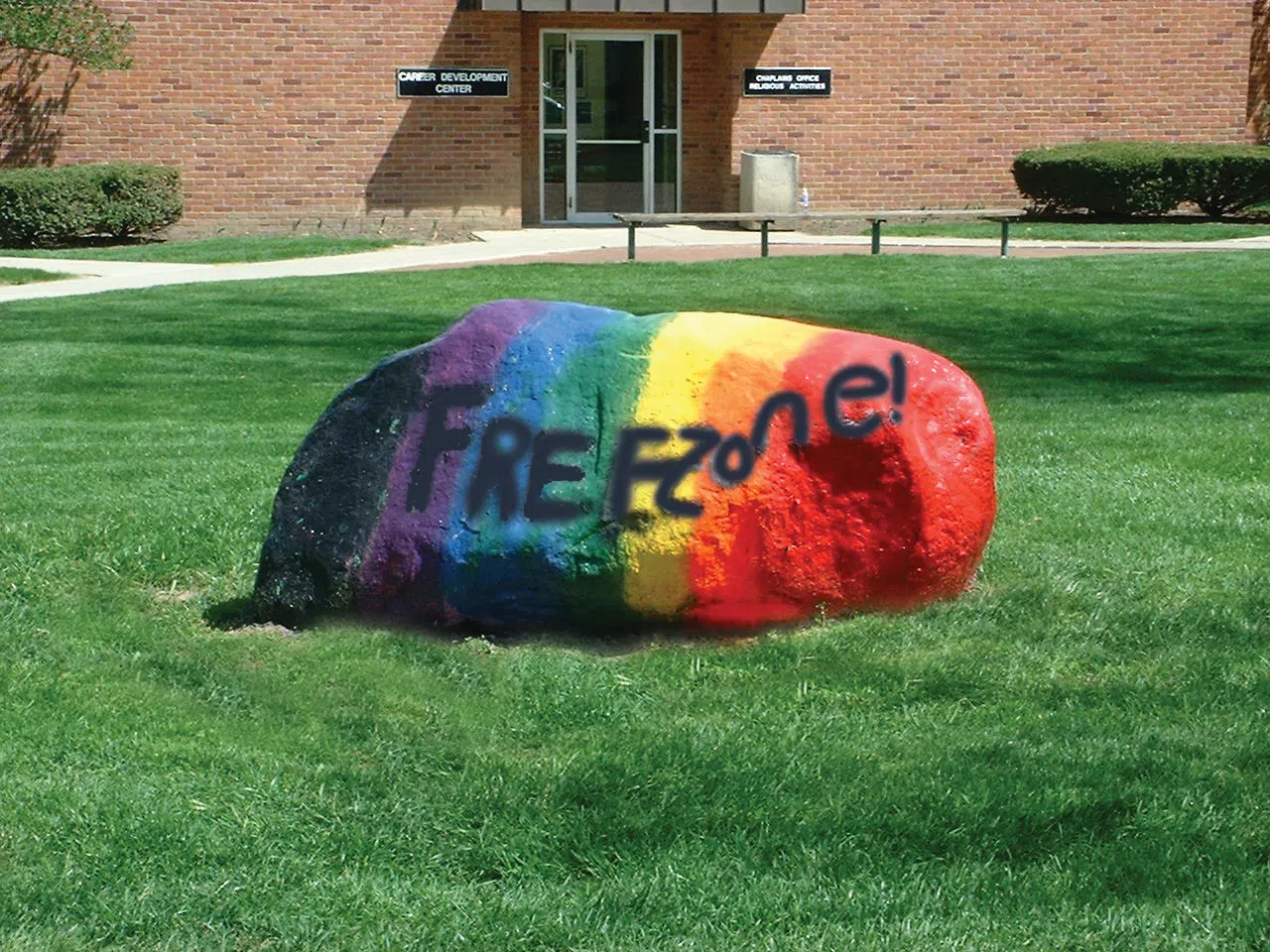 A large rock in front of Hanby Hall is painted in rainbow colors and has "Freezone!" written on it with paint.