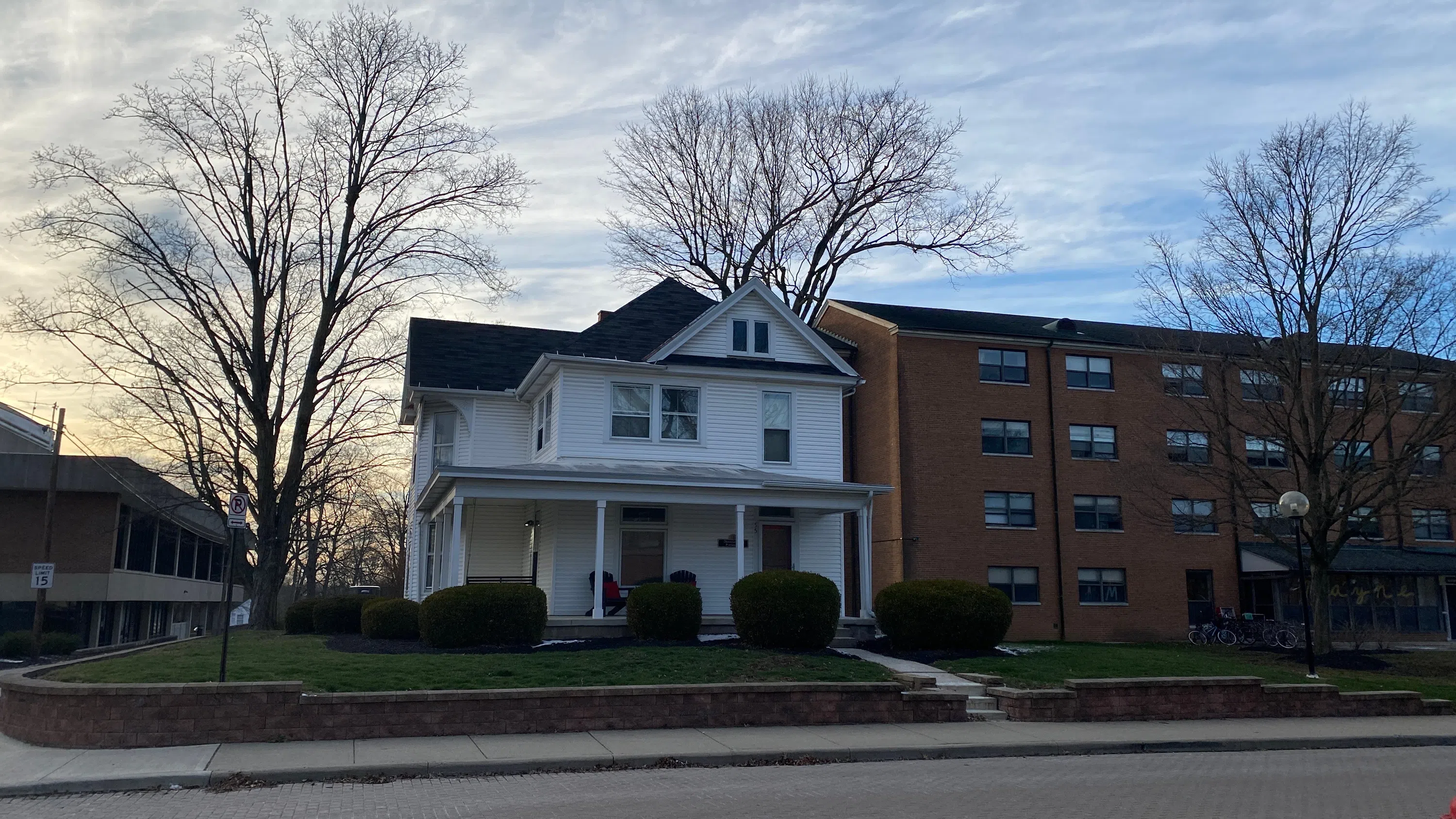 A white house with black roof. Sign reads Psychology House.