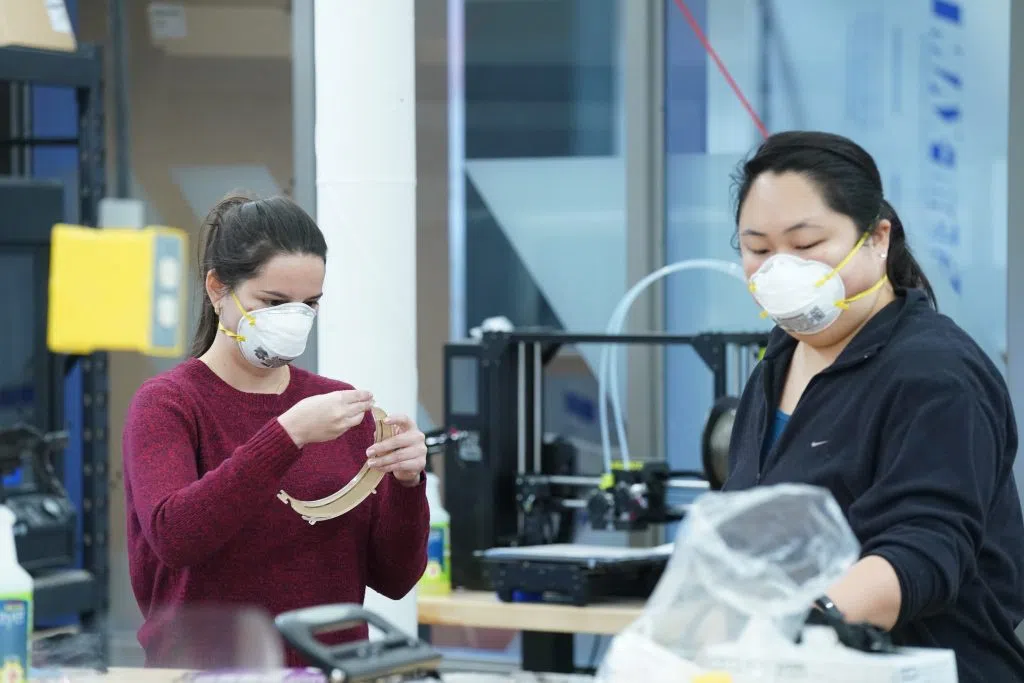 Two women create PPE with 3D Printers.