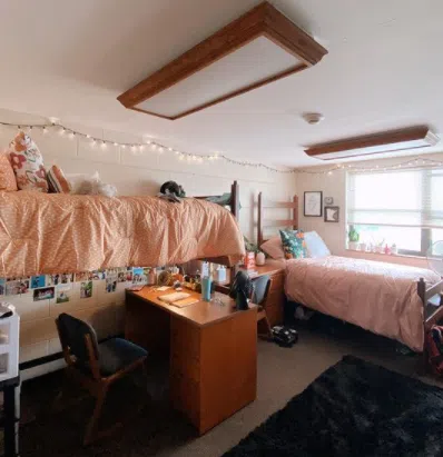 Sample dorm room in Mayne Hall. Two beds, one set up as a bunk with a desk underneath.