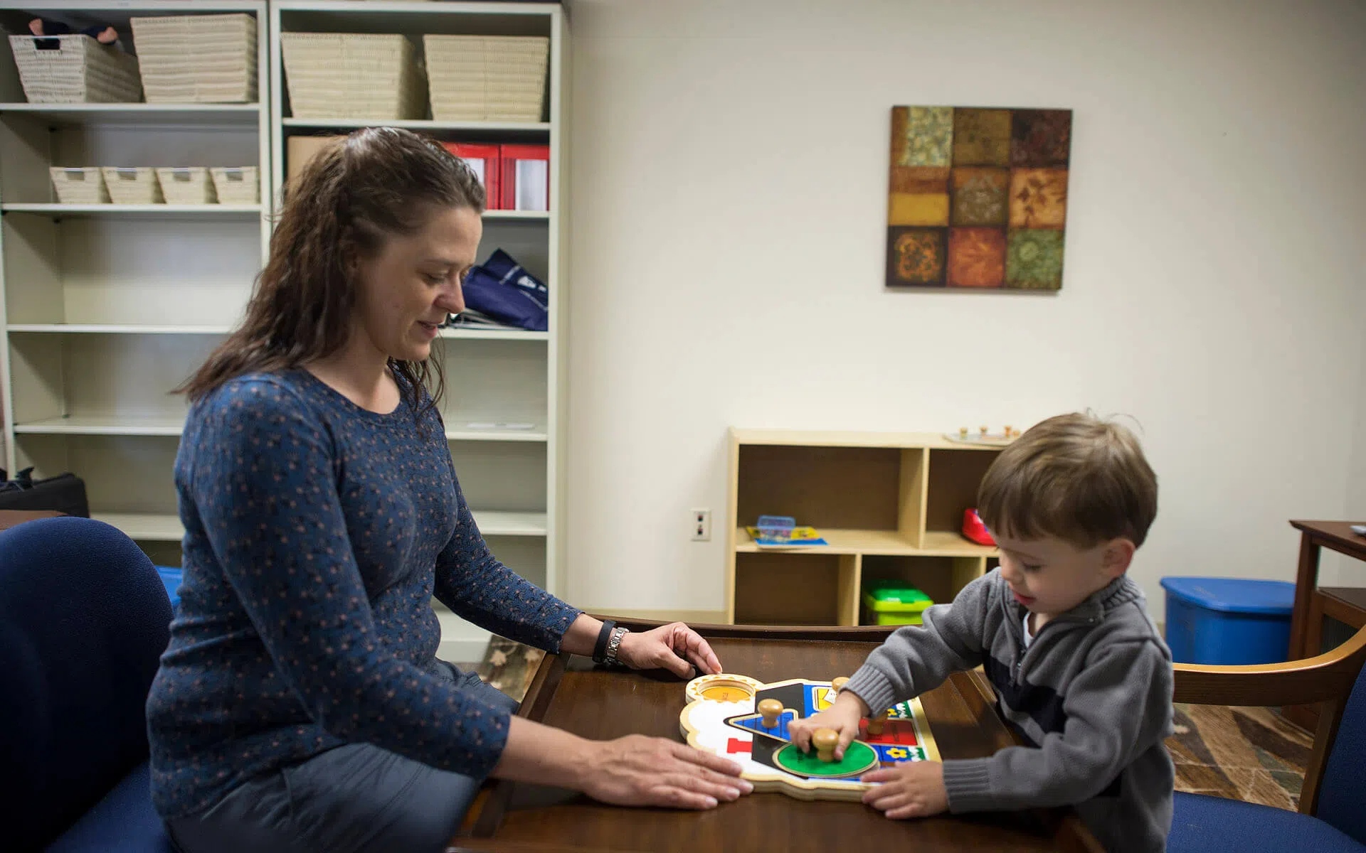 A woman works with a child in a 1 on 1 setting