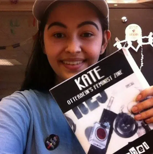 A student holds up a copy of kate, Otterbein's feminist 'zine.