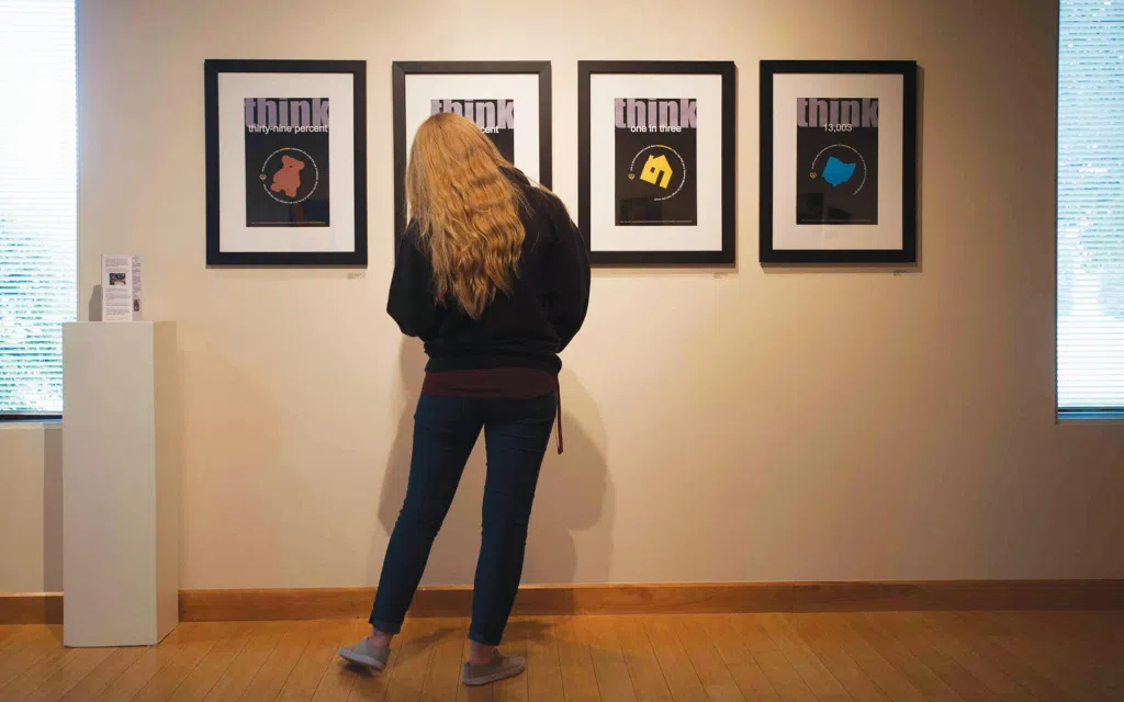 A person stands in front of an art display.