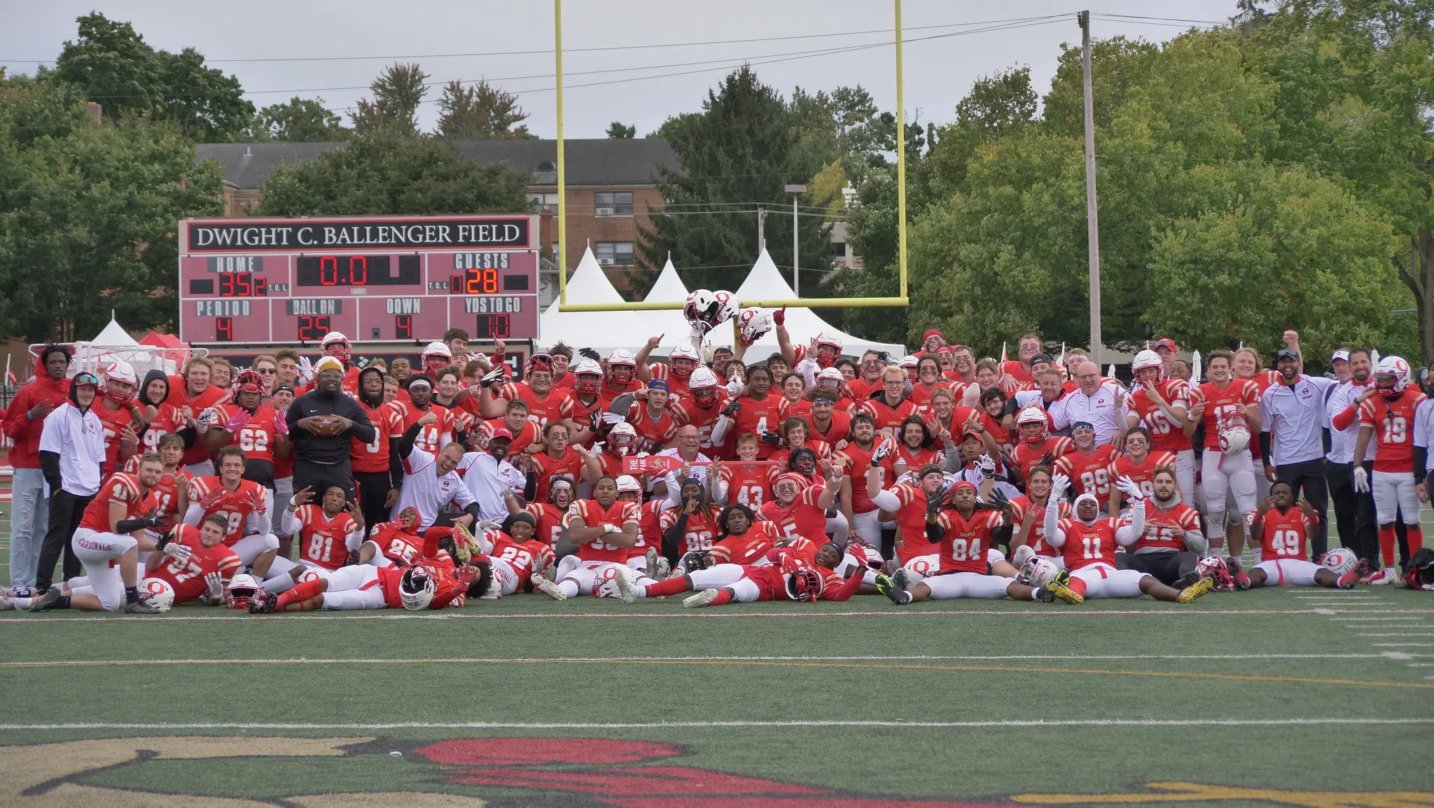 The football team poses proudly for a photo on the field