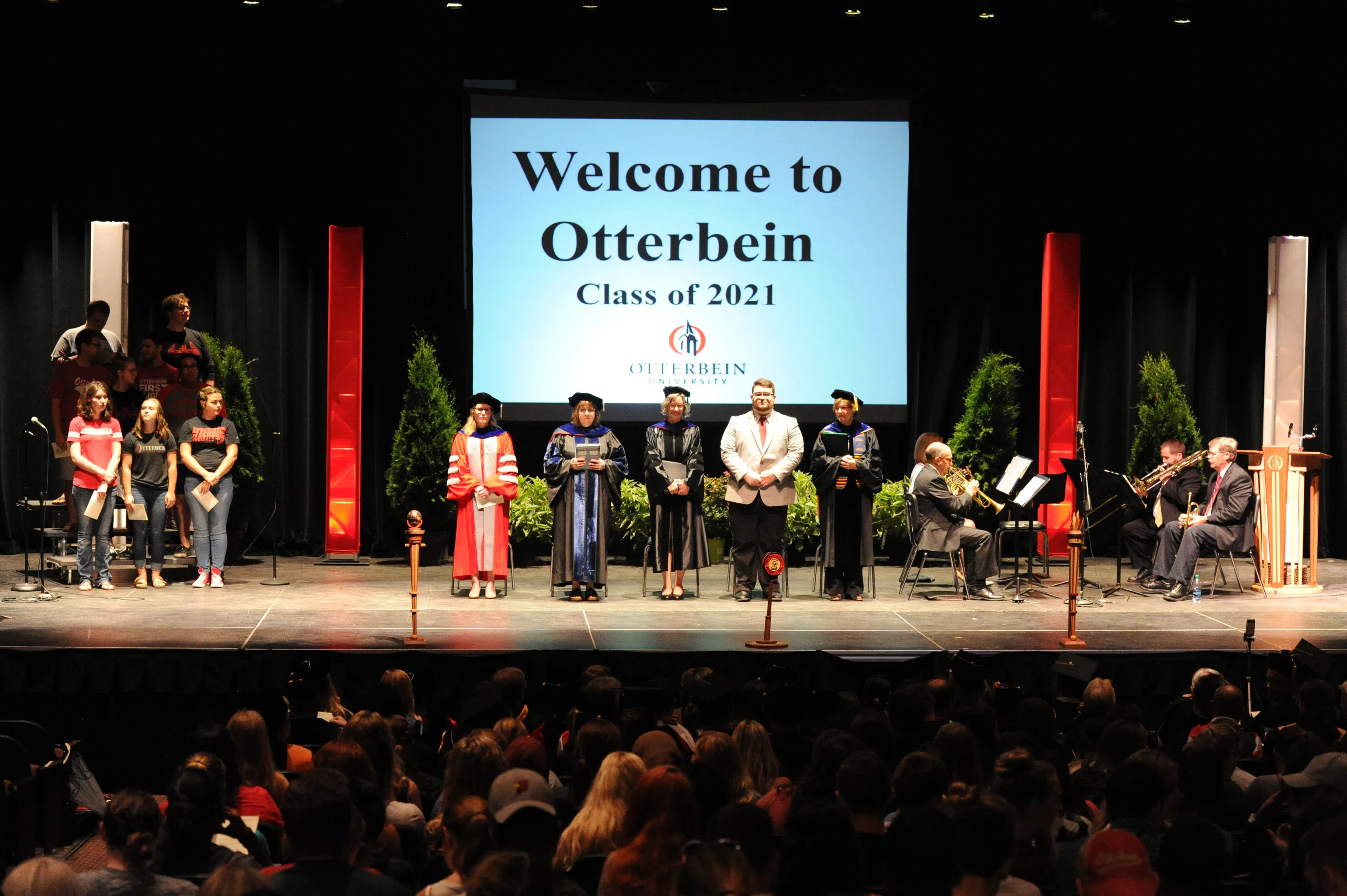 A Welcome to Otterbein powerpoint is displayed in the theater setting.