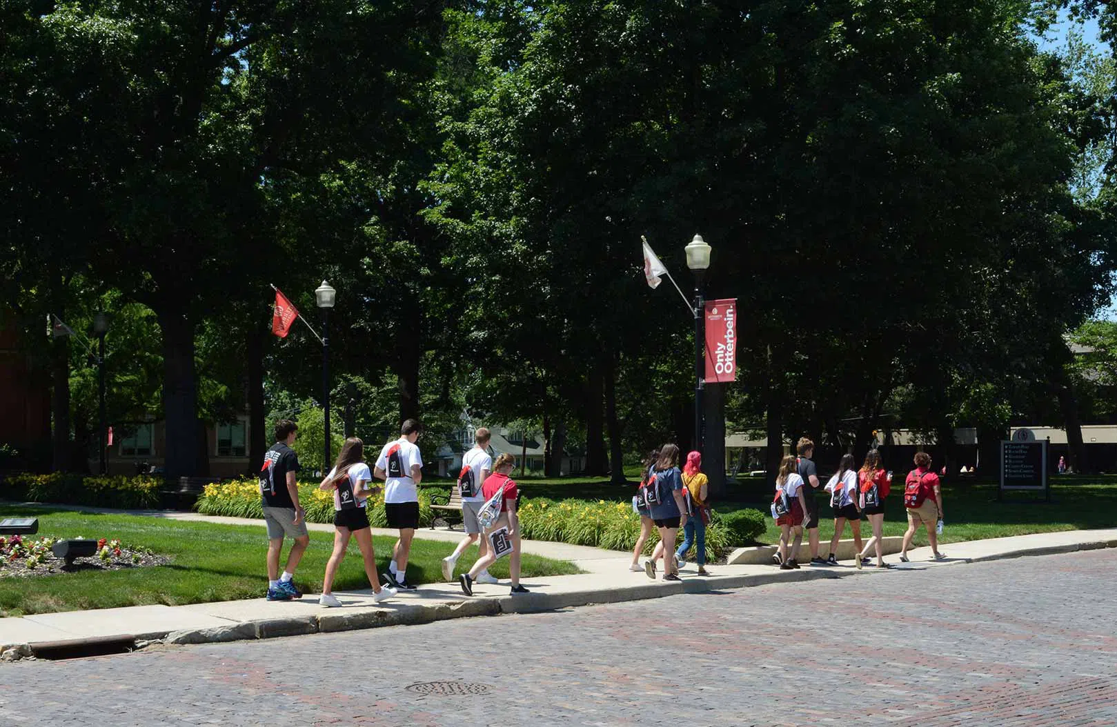 A group of new students walk across the street from Clippinger hall.