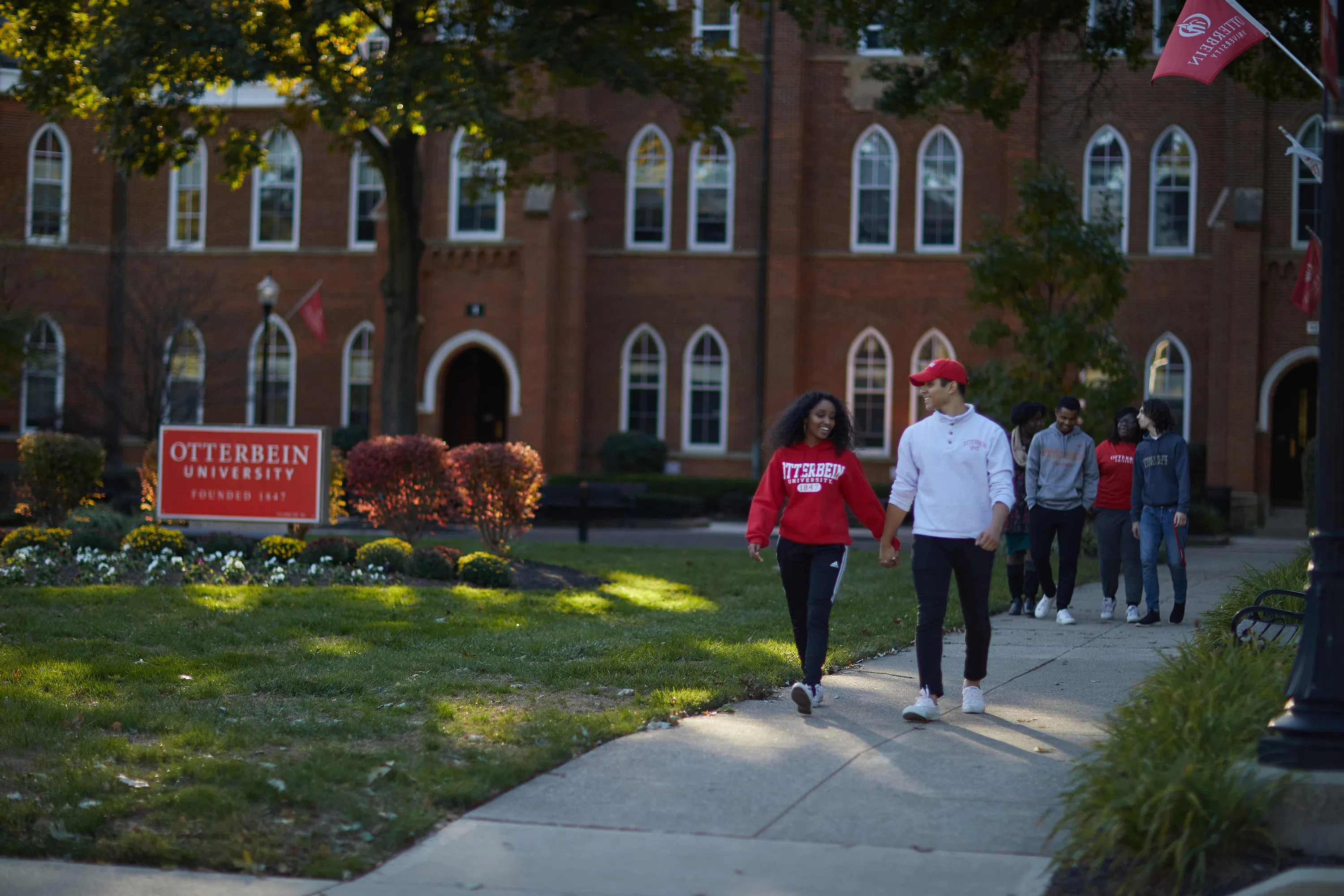 A group of students smile as they walk together outside Towers Hall.