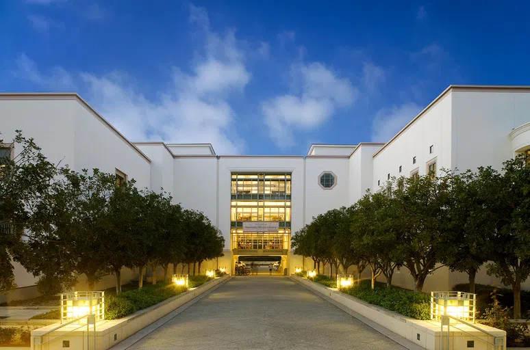 Front view of Honnold/Mudd Library at night with lights