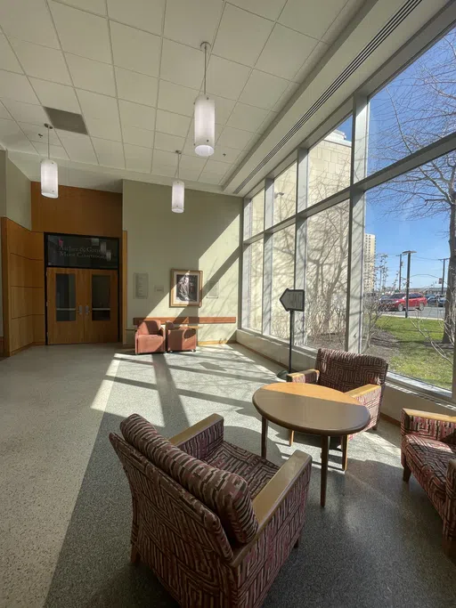 Image features a set of tables and chairs along the window while the entrance to the mock trial room can be seen.