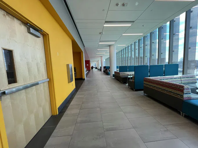 Lounge seating is located adjacent to the main hallway.