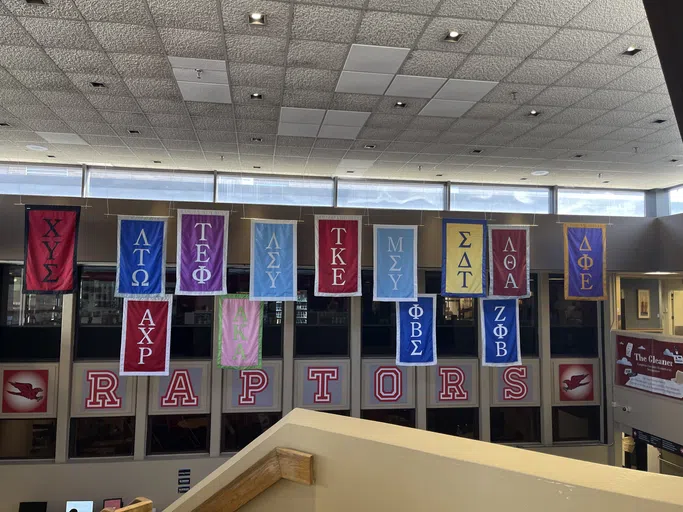 Greek Life signs hang from the ceiling.