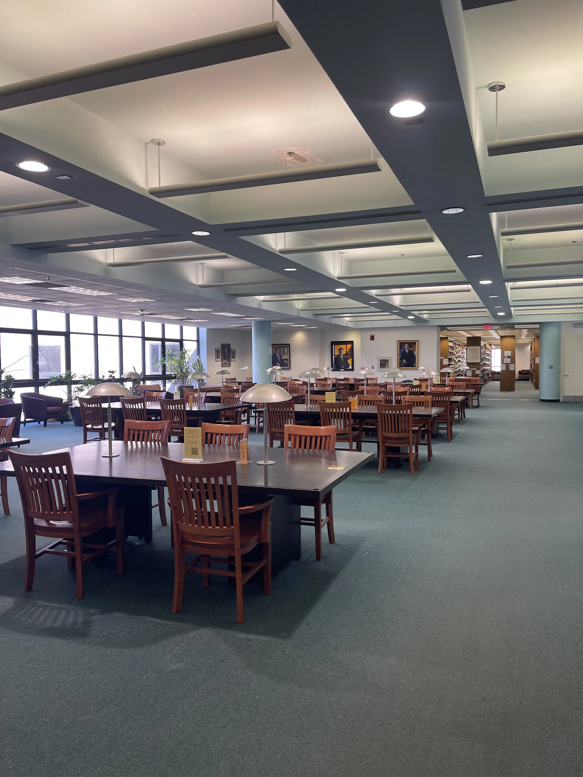 Rows of tables and chairs line the room with lamps on each table.