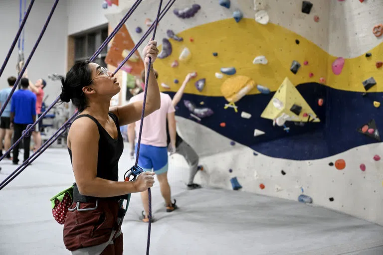 A student belaying at the rock climbing wall 