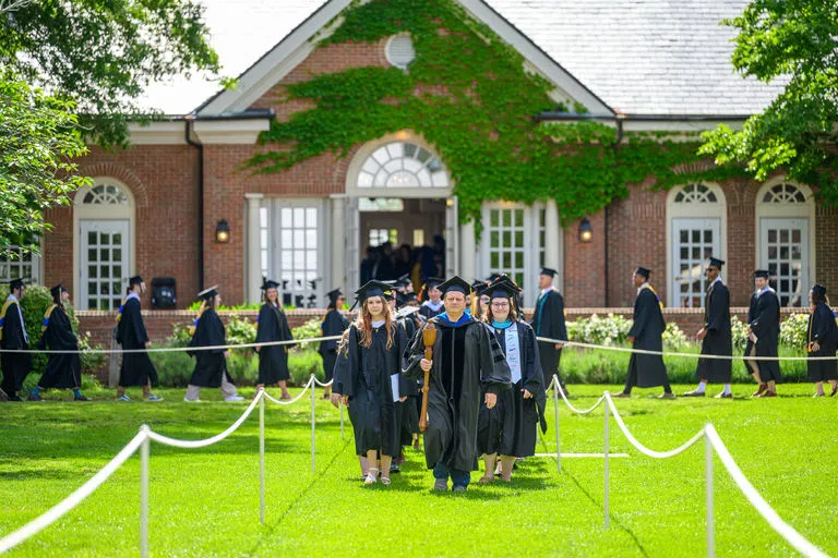 Faculty lead students through the greens. The Daugherty Palmer Commons is in the background.