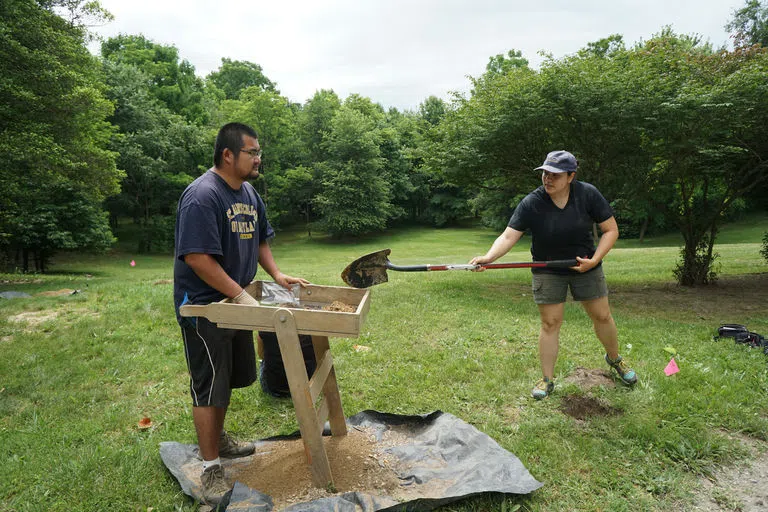 Two people at an active archeological dig site