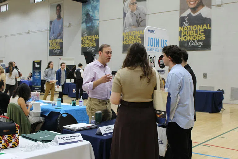 Employers talking to current students at a career fair held at the Rec Courts