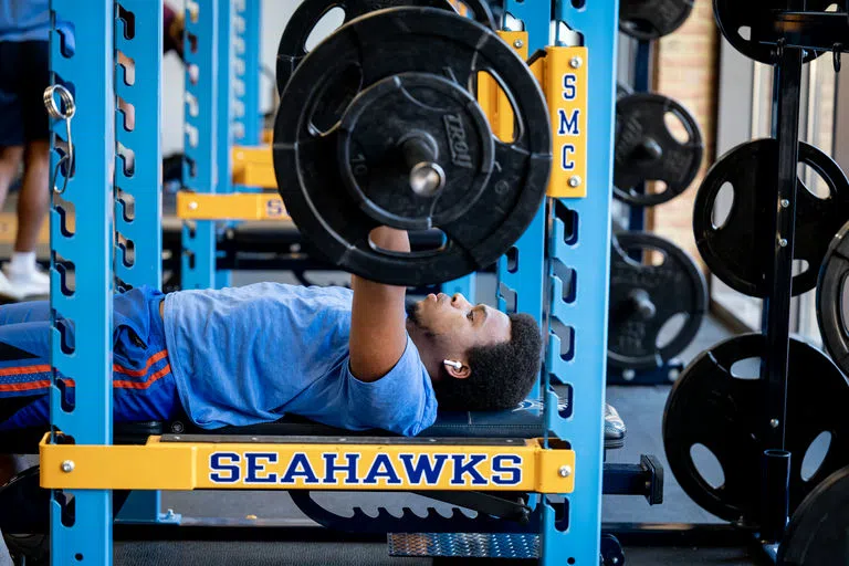 Student bench pressing a barbell