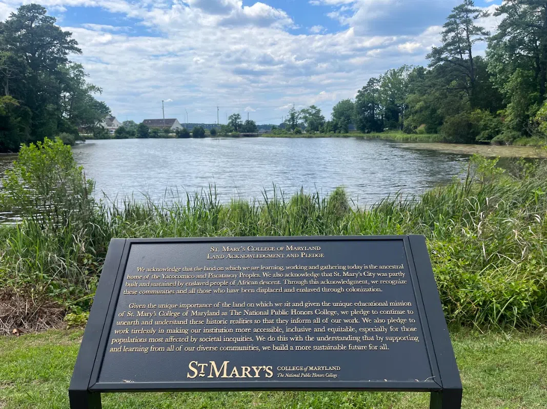 A plaque with the Land Acknowledgment before the St. John's pond.