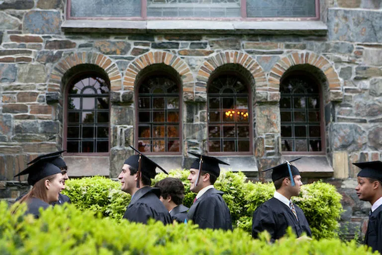 Tufts graduates walking past Goddard Chapel