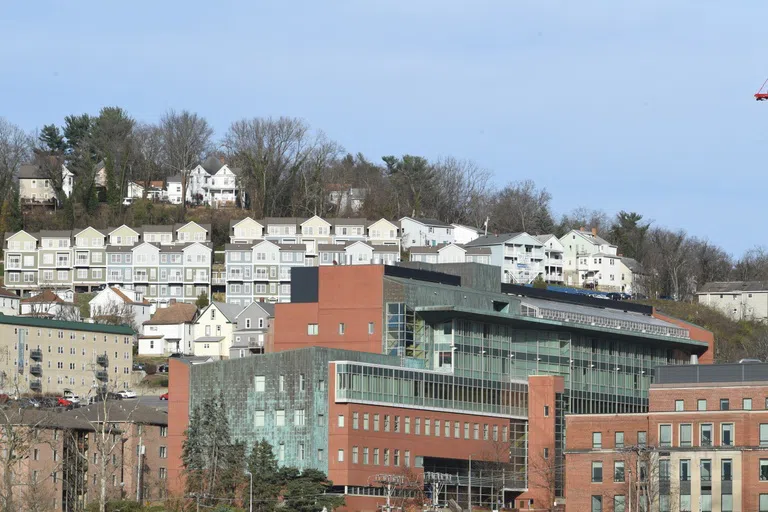 A photo of the Life Sciences Building with examples of Off-Campus Housing visible beyond it