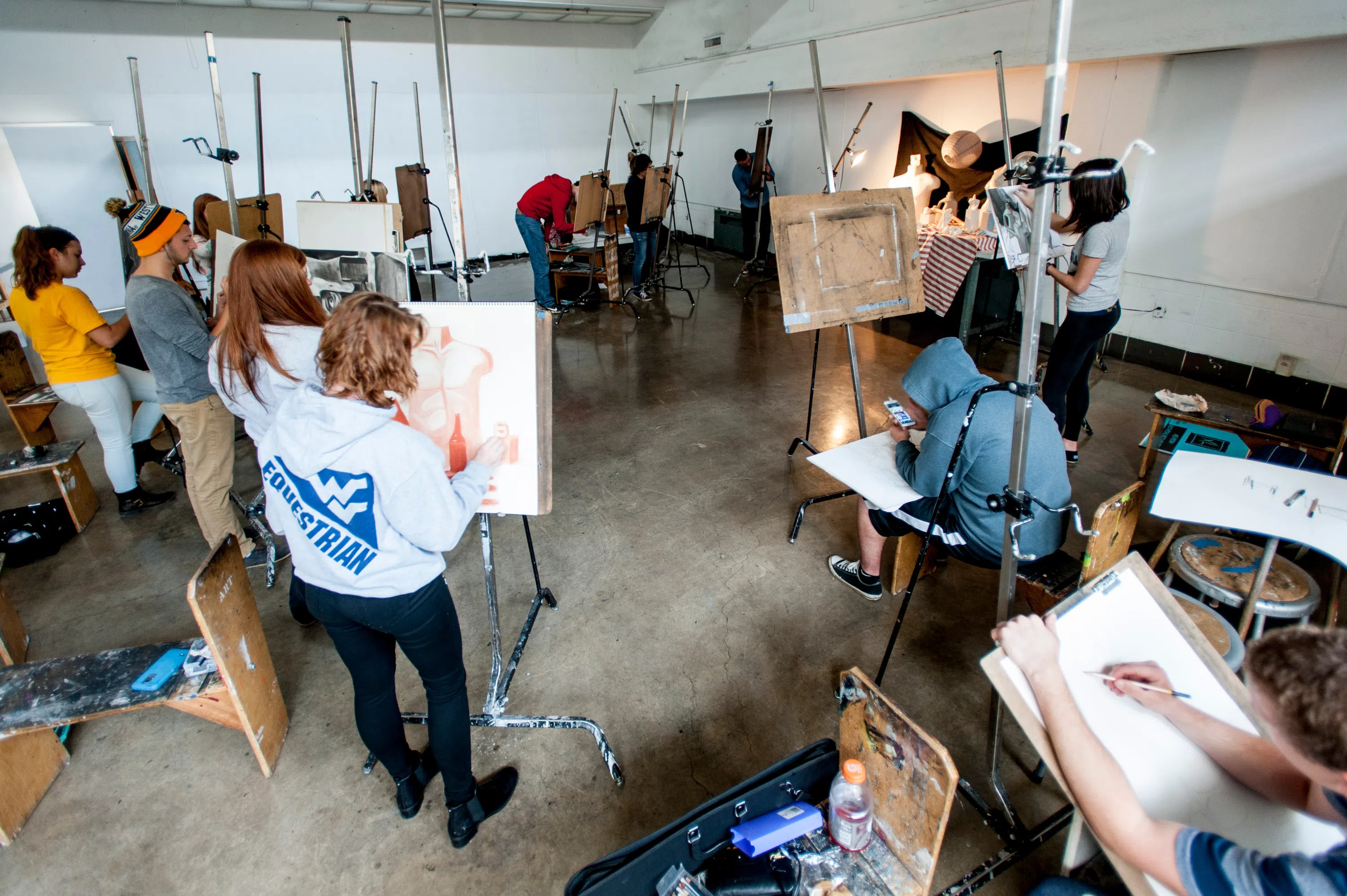 A group of WVU students draw a subject in a drawing class 