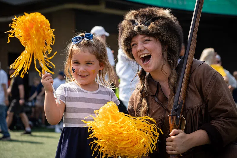 Mountaineer, Mary Roush, cheers on the team alongside one of our younger fans.