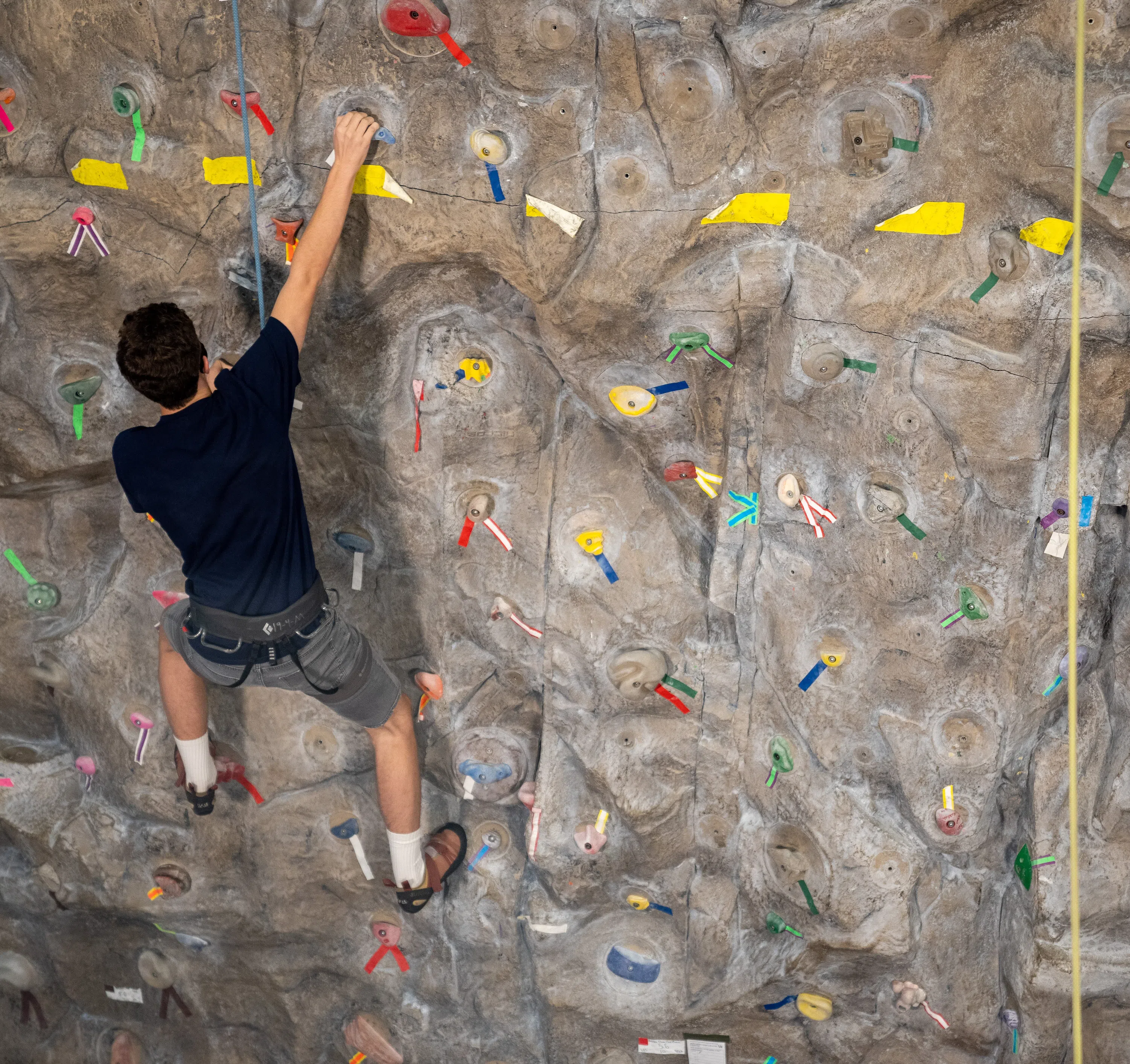 Action shot of a student climbing the recreation center's rock wall. 
