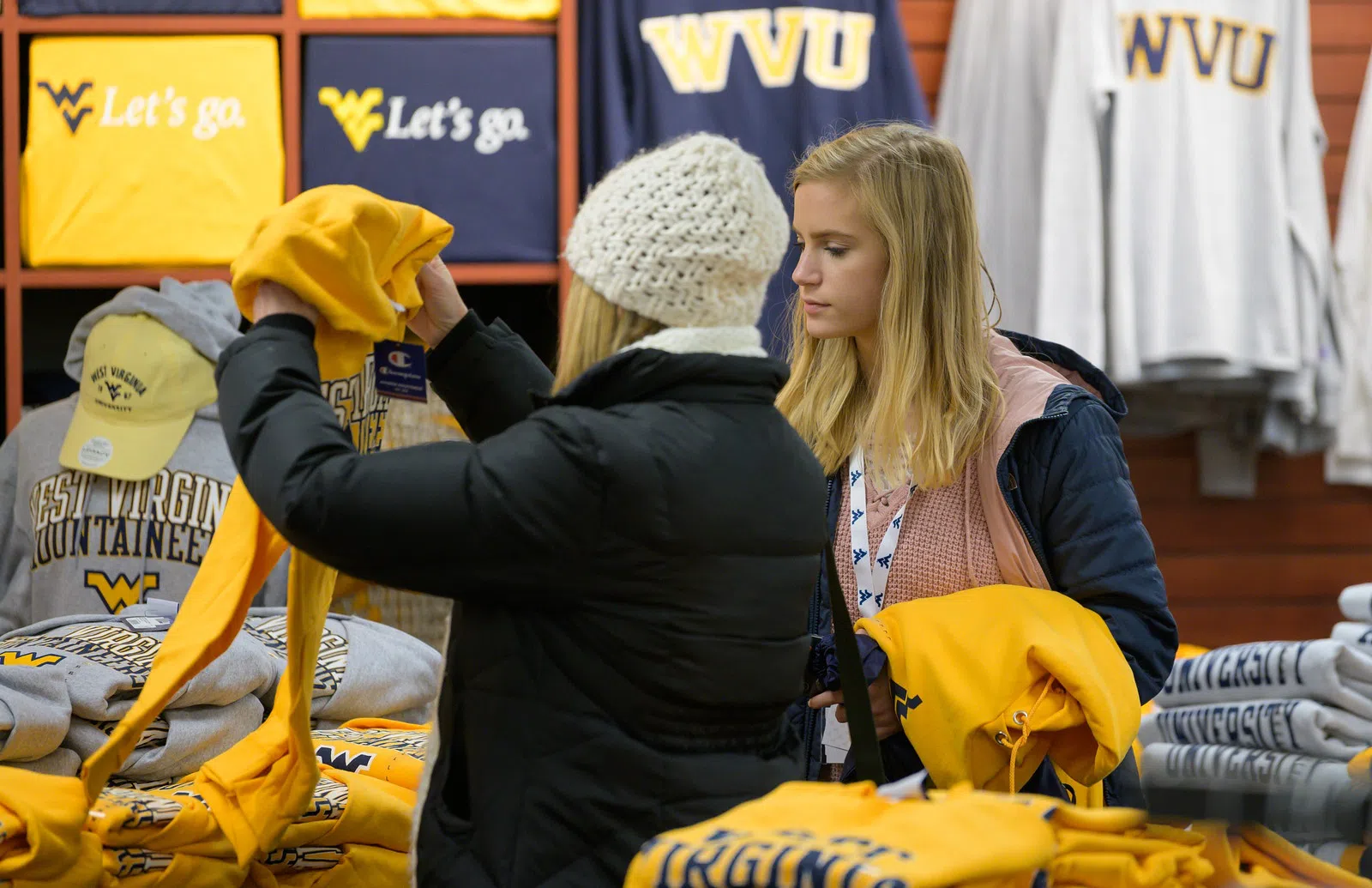 Two individuals browse through WVU gear in the bookstore. 