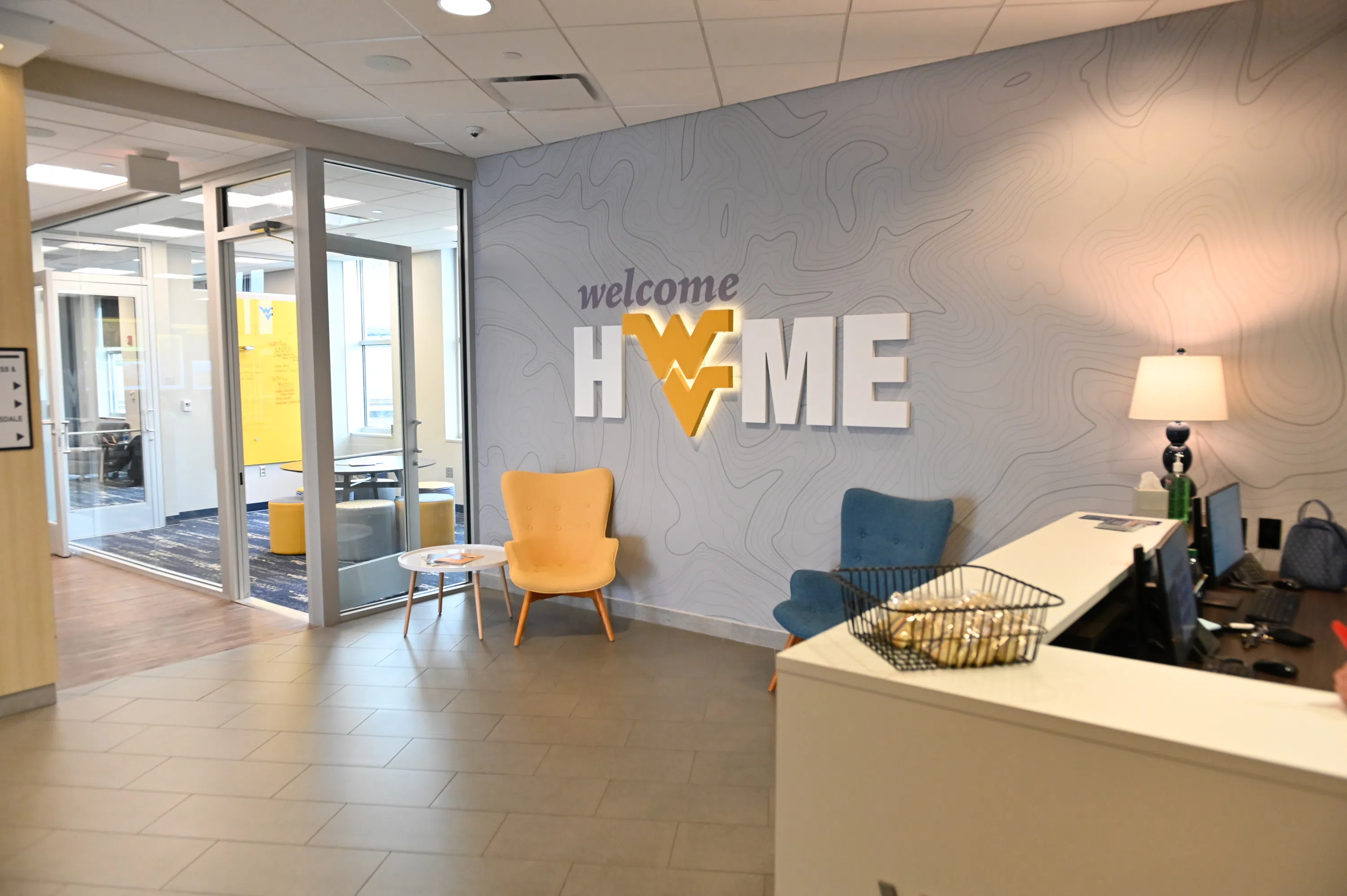 The front desk of the Evansdale Visitors Center with the "Welcome Home" sign.