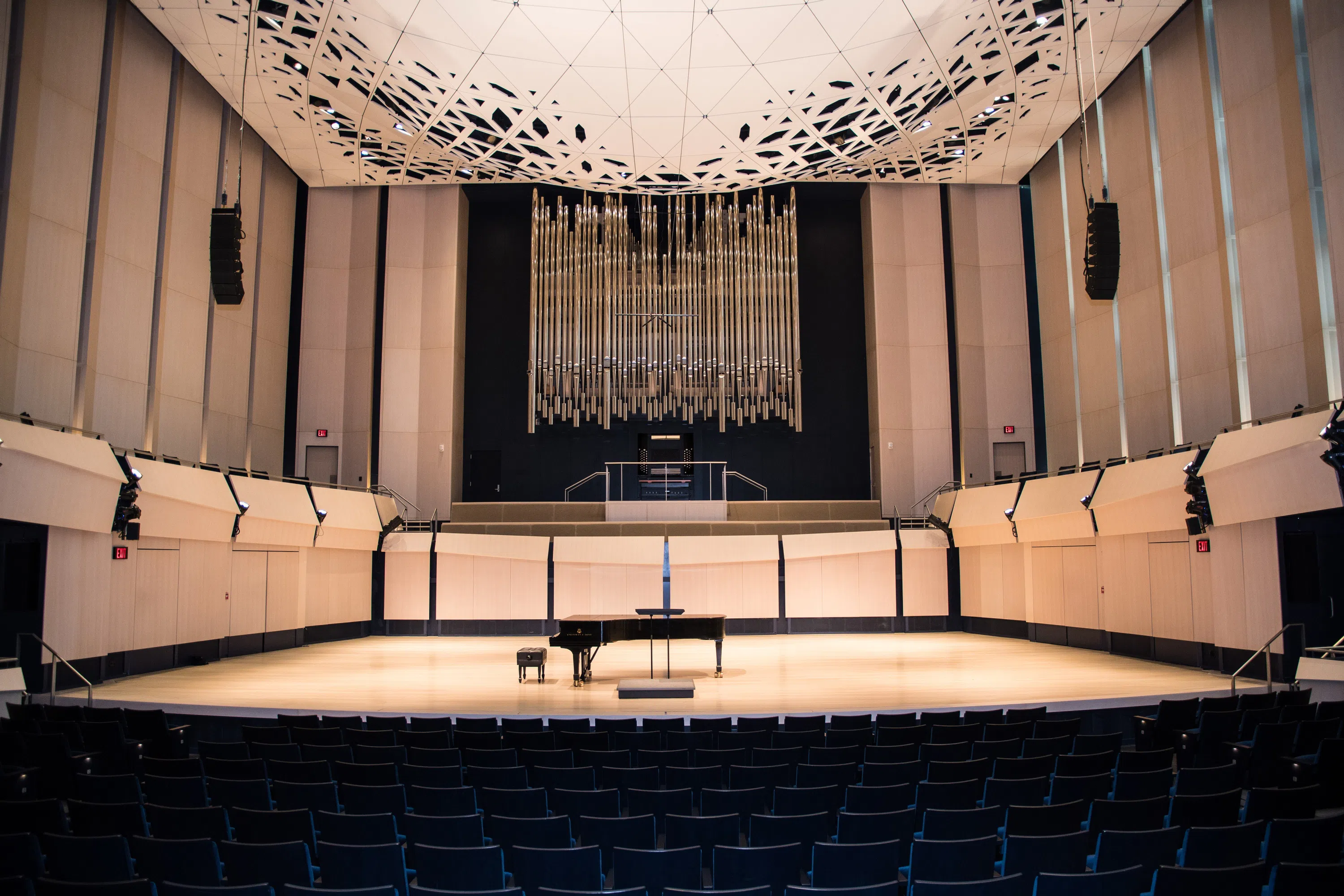 Internal view of Voxman performance hall featuring a piano in the middle of the stage