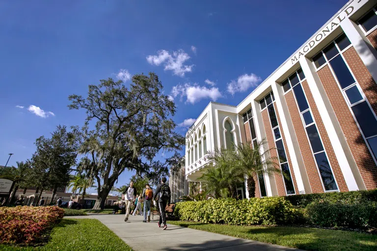 Students walking past library exterior.