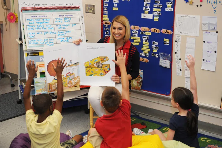 Student reading to classroom of young people