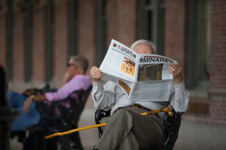 Professor reading UT Newspaper: The Minaret