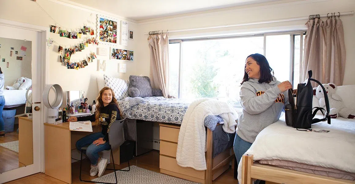 Two students talk in their residence hall room in Delaware Hall