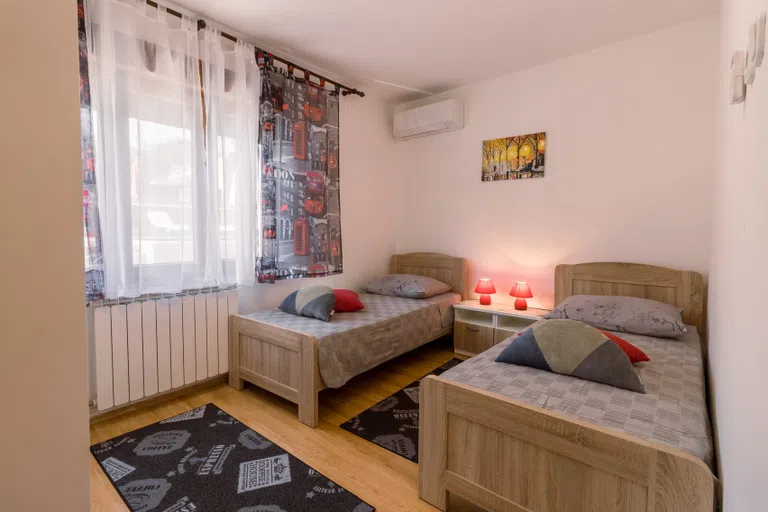 Two beds with lamps, carpet and window for a sample residence hall