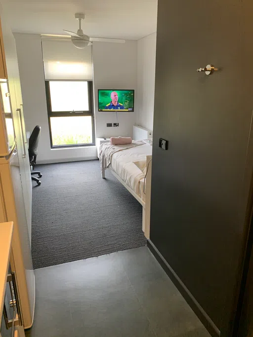 Residence hall room with bed and TV