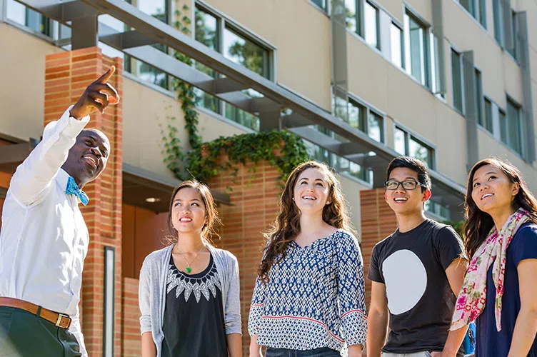 Tour guide with prospective students walking around campus