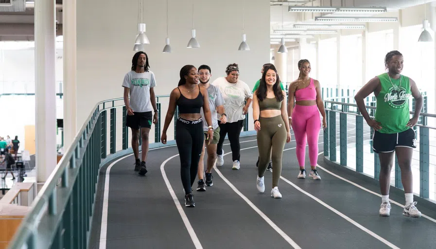 Students walk in a group on the indoor track