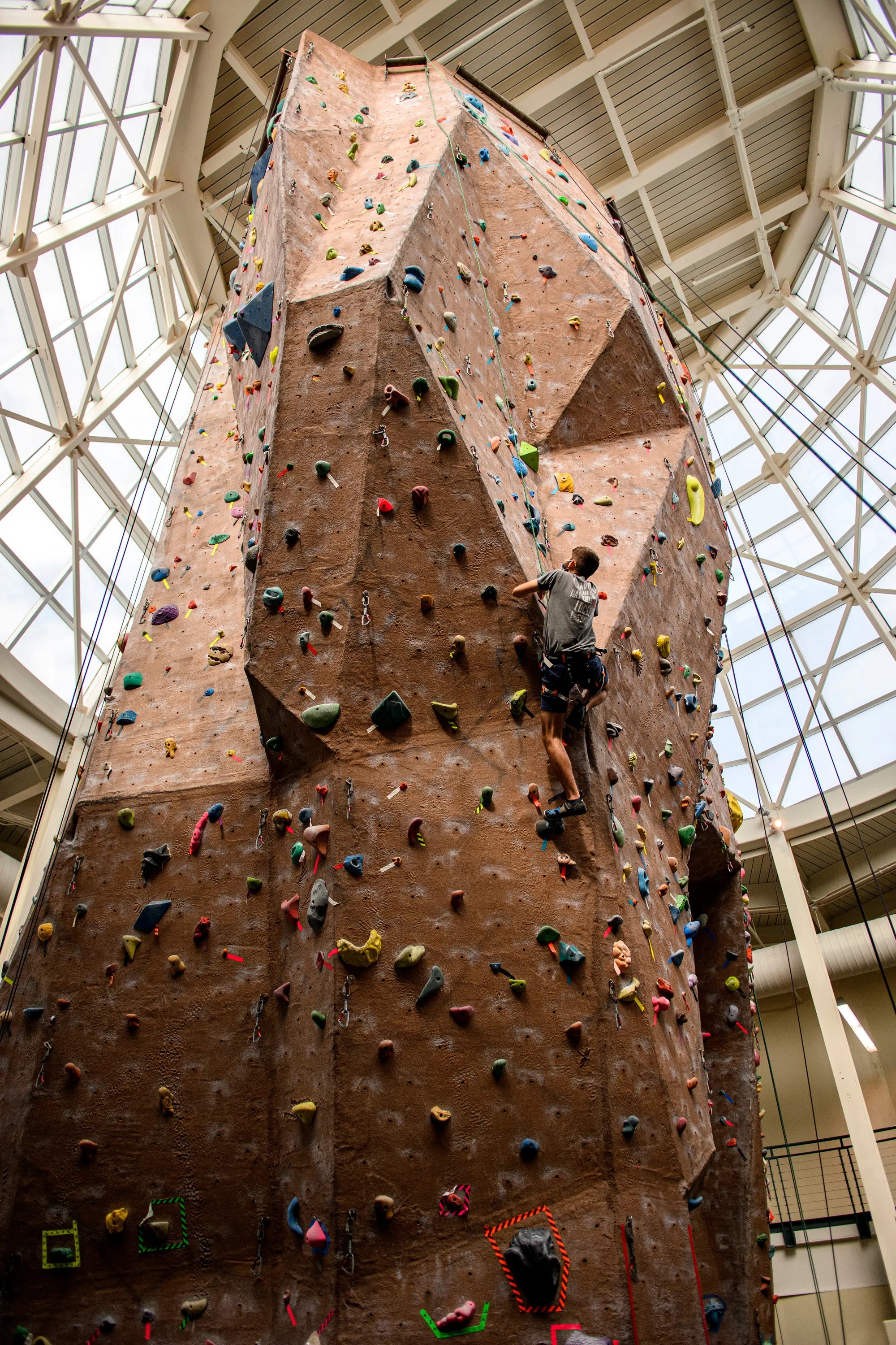 Student scales the indoor rock climbing wall. 