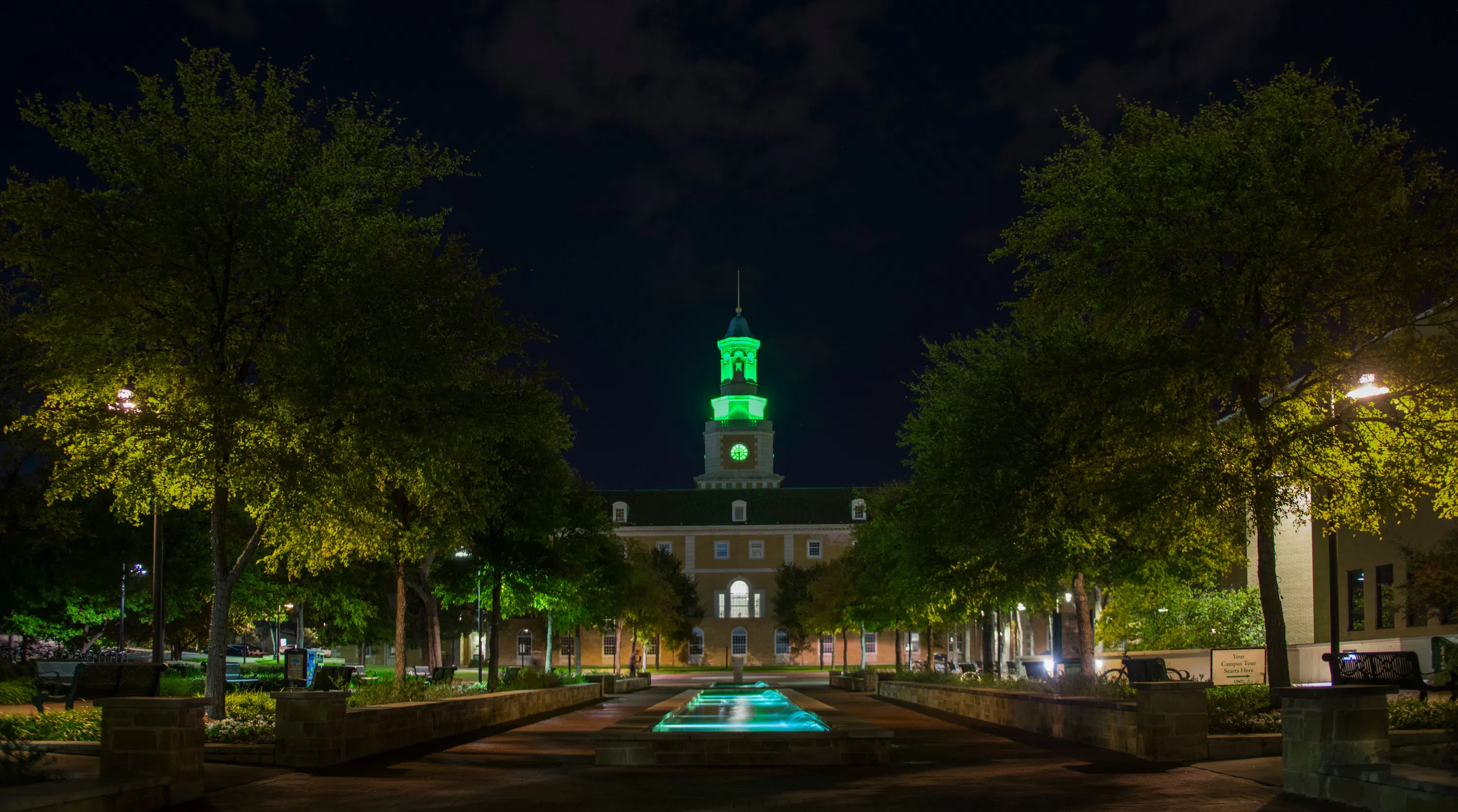 McConnell Tower lit up green at night. 
