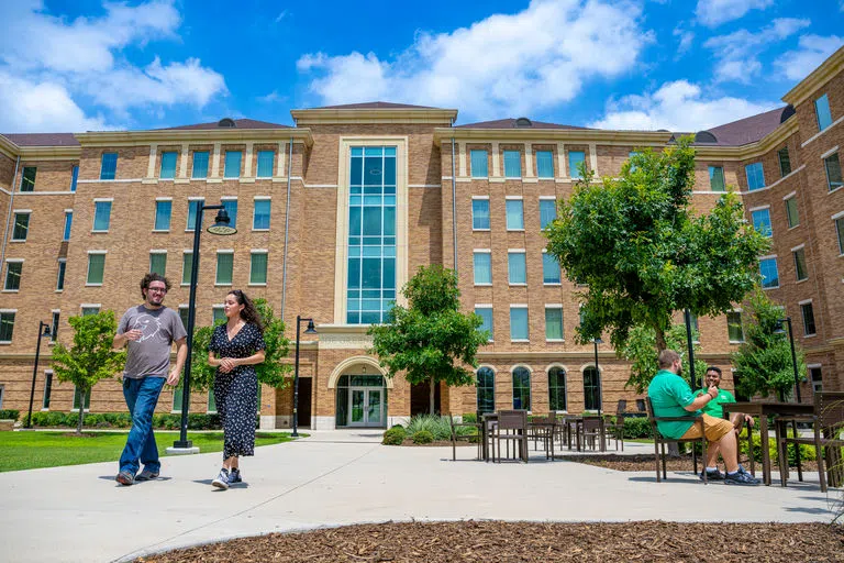 Exterior of Joe Green Hall with students heading to class. 