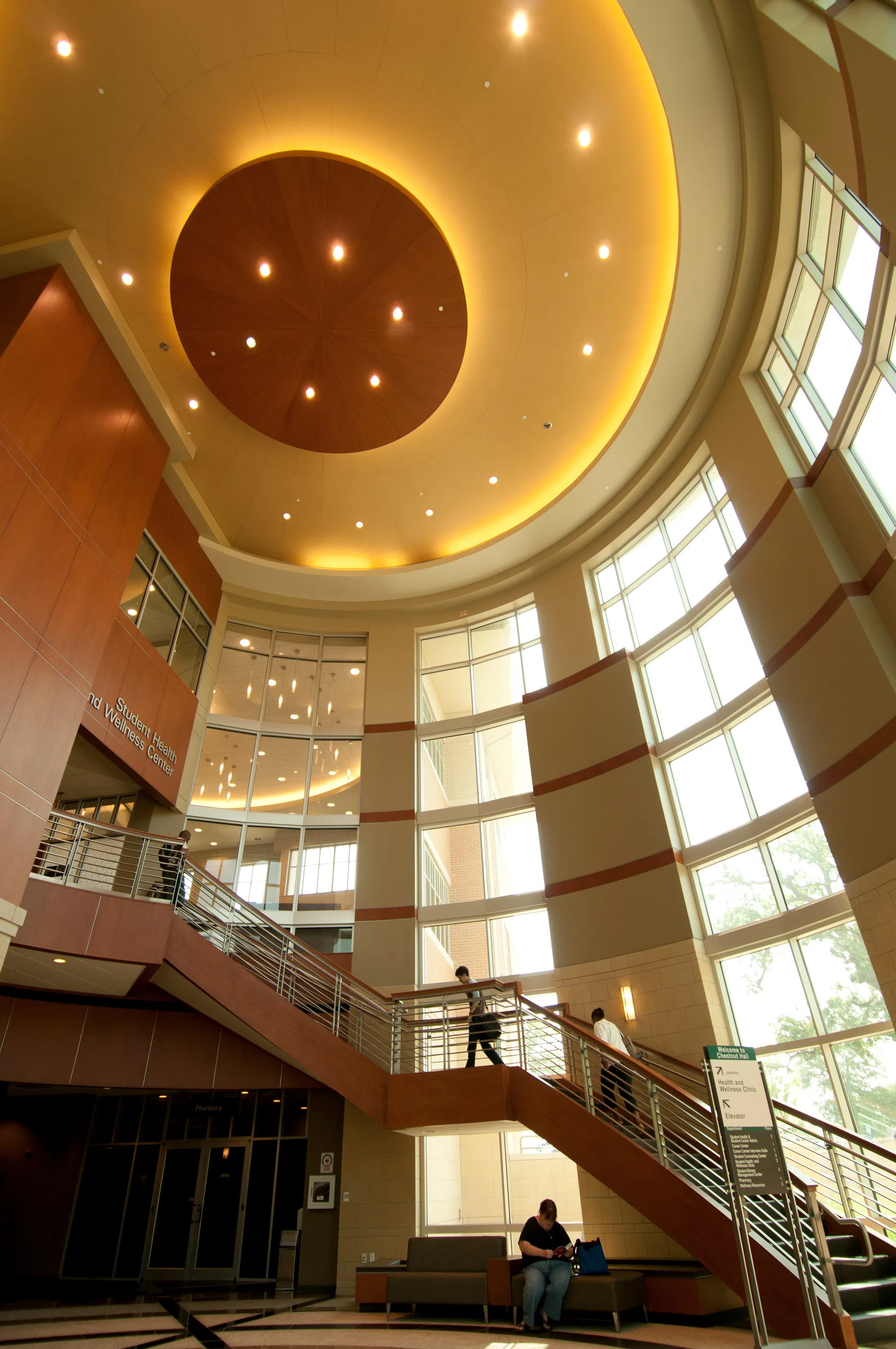 Interior of Chestnut Hall. A student walks up a staircase leading from the entrance up to the Student Health and Wellness Center. 