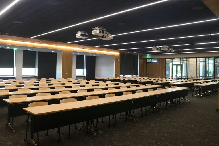 A picture of the rows of empty chairs with desks, ready for the next event. 