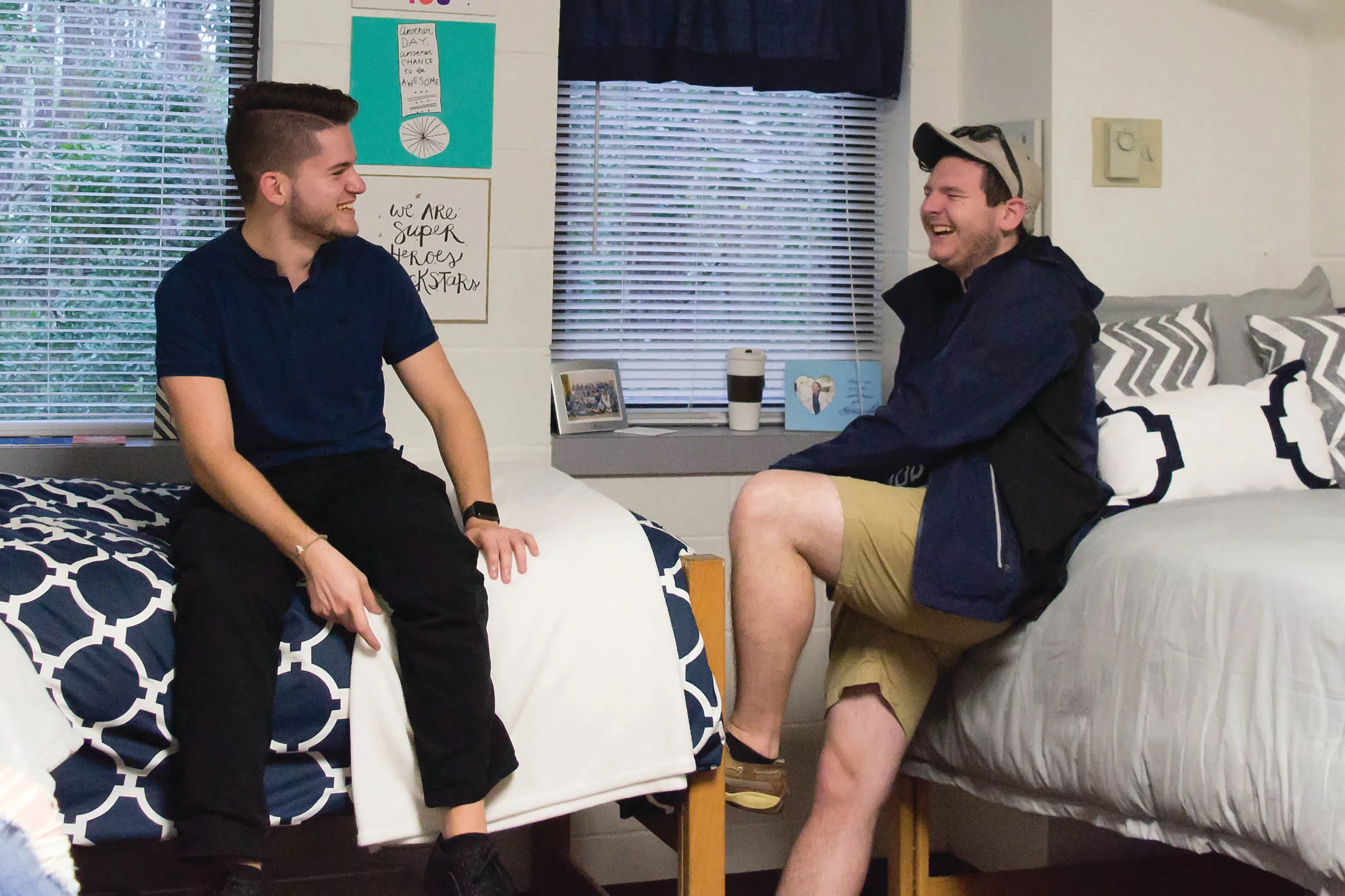 Students sitting on beds and laughing in first-year decorated room