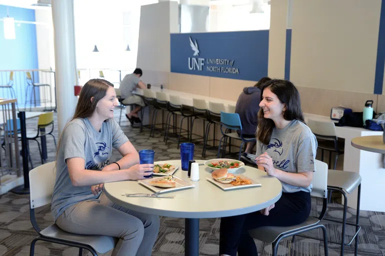 Two students eating at table in Osprey Cafe