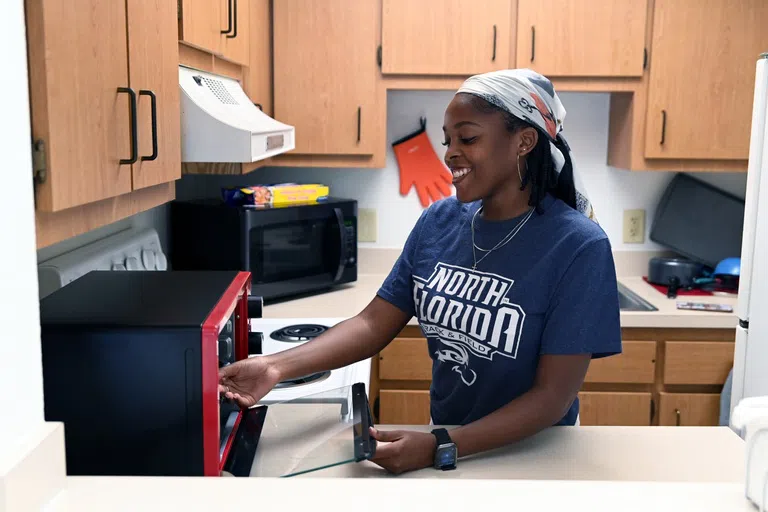 Student cooks in residential room kitchen