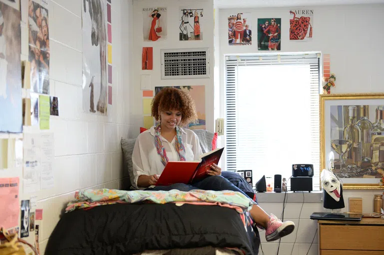 Student reading on bed in decorated first-year room